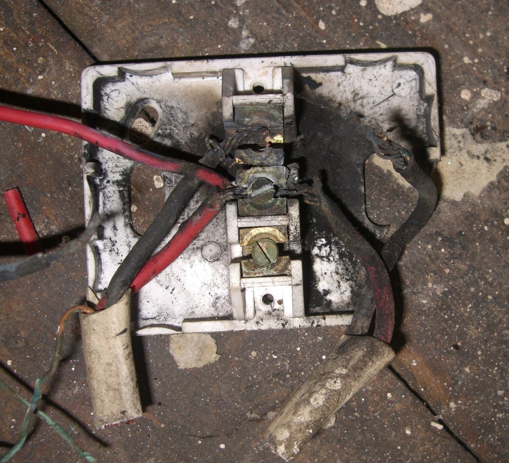 Burnt junction box showing electrical arcing under floor in Banbury