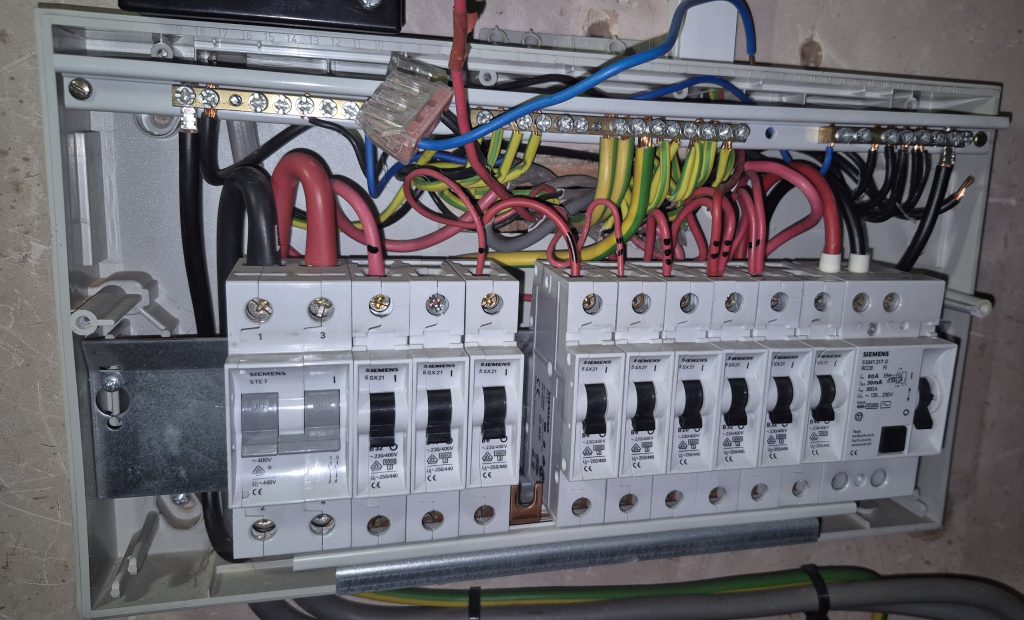 Inside older consumer unit before electrical upgrade in Banbury