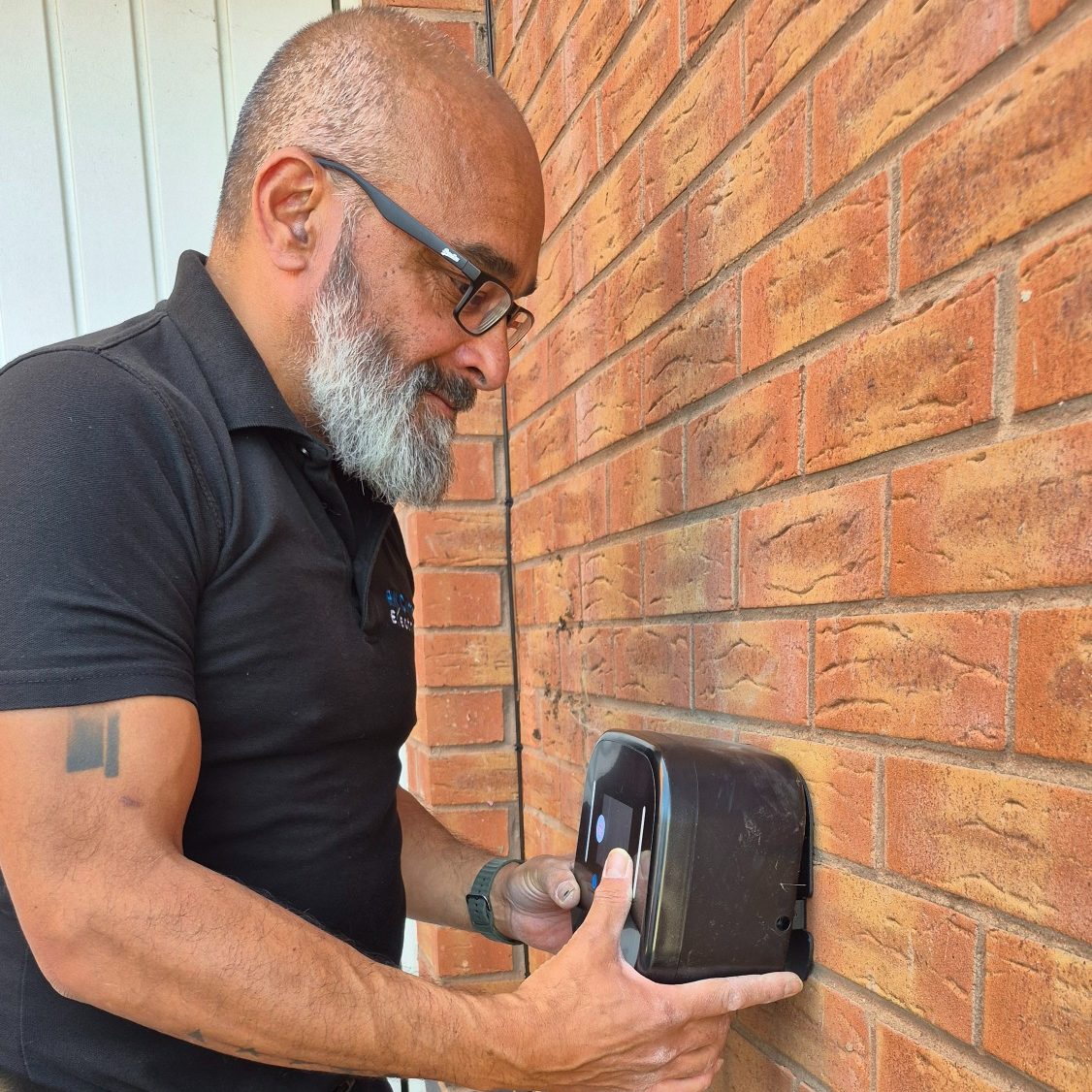 Richard Currion installing an Ohme EV charger at a home in Adderbury near Banbury