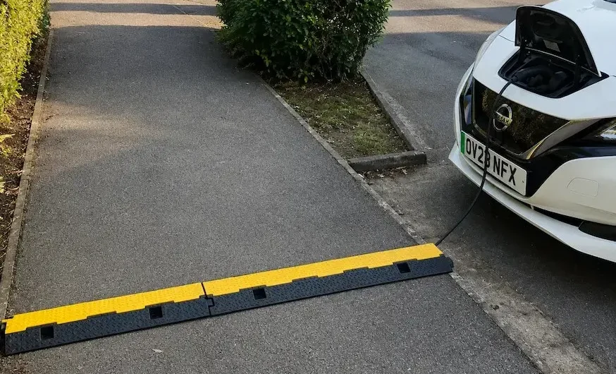 EV charging cable trip hazard across a path.
