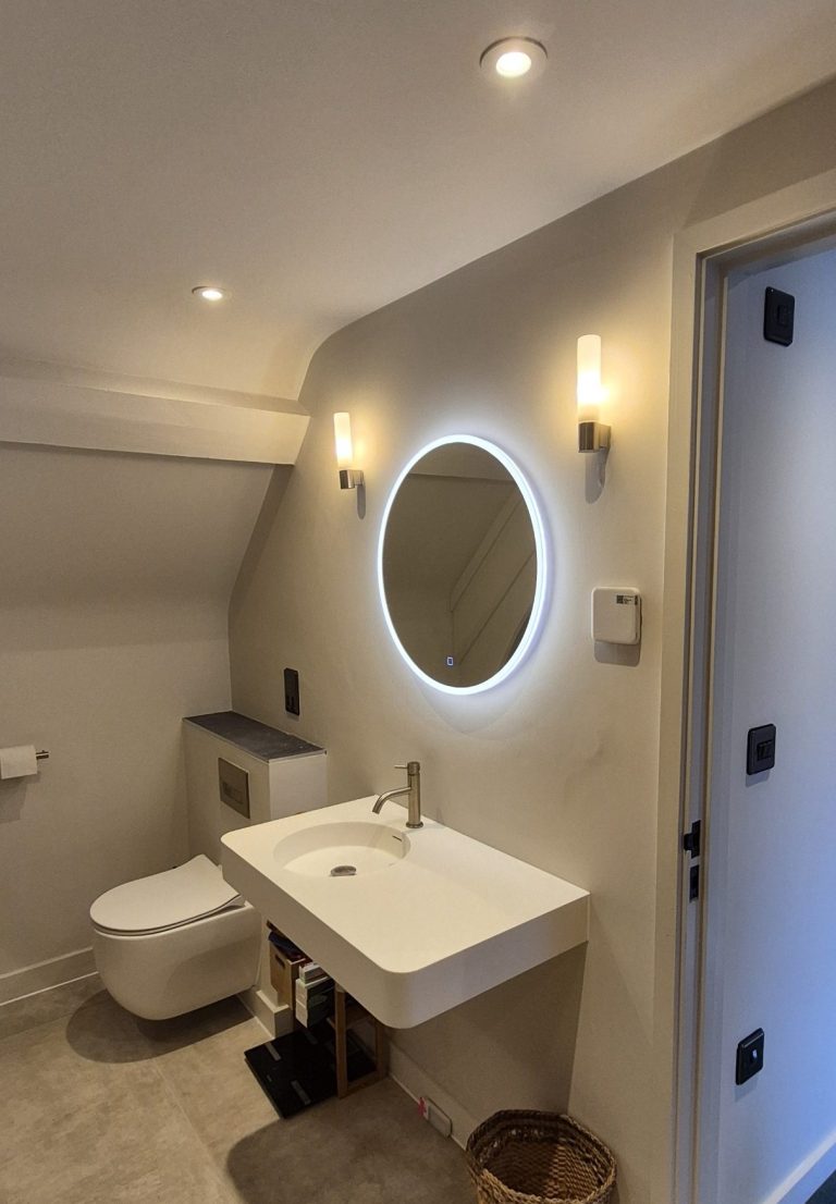 Bathroom with illuminated mirror and wall lights installed by electrician in Banbury